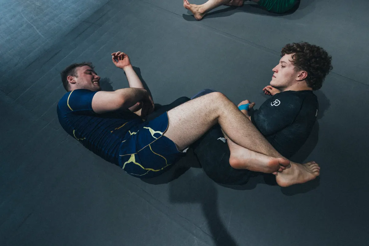 No-Gi-Training: ein Athlet kontrolliert seinen Partner aus der Guard